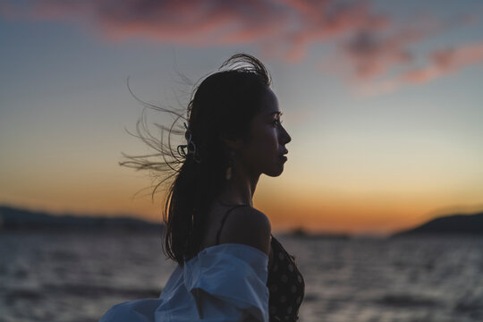 夕暮れの海にいる女性