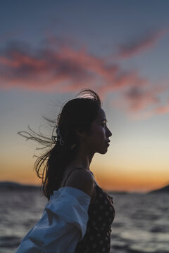 夕暮れの海にいる女性