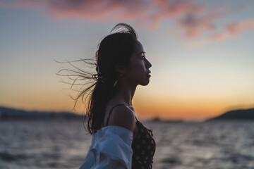 Fototapeta premium 夕暮れの海にいる女性