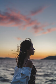 夕暮れの海にいる女性