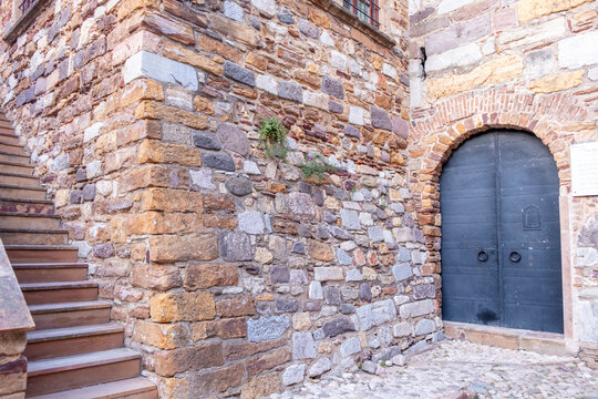 Historic stone building with arched metal doorway and staircase in Chios Town Greece
