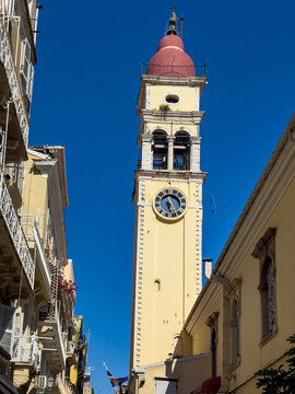 Saint Spyridon Church clock and bell tower above the narrow streets and Venetian buildings of Corfu Old Town, Greece.