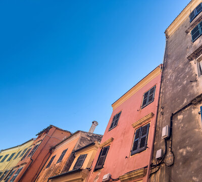 Pastel traditional buildings with dark shutters, low-angle view, Corfu Old Town, Greece