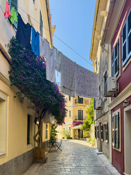 Colorful laundry above stone alley with shutters in Corfu Old Town, Corfu, Greece
