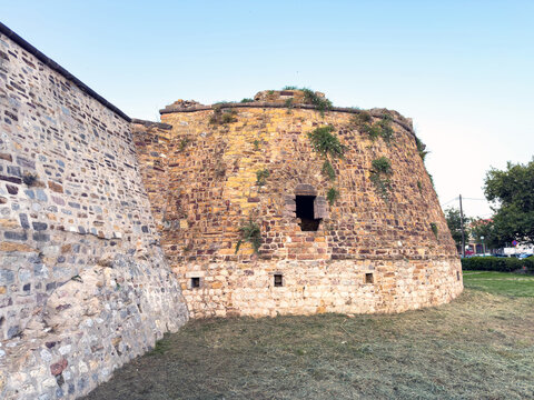 Weathered stone bastion and defensive walls above dry moat at Chios Castle, Greece