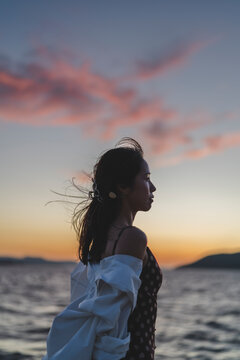 夕暮れの海にいる女性