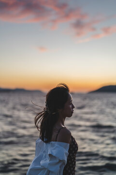 夕暮れの海にいる女性