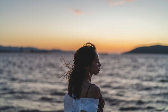 夕暮れの海にいる女性