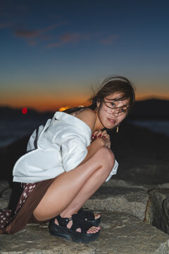 夕暮れの海にいる女性