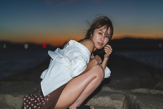 夕暮れの海にいる女性