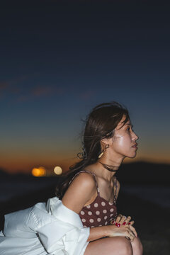 夕暮れの海にいる女性