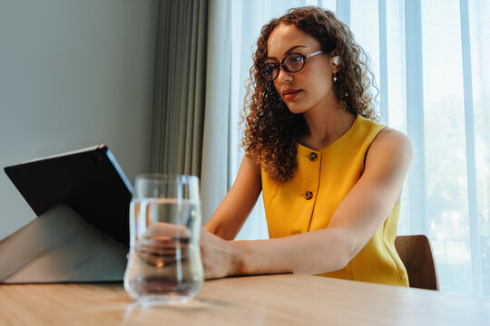 Focused african american woman using a tablet at home office desk