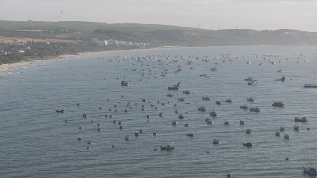 Aerial drone view of Mui Ne fishing village and Ganh Da Mui Ne coastline in Lam Dong, Vietnam, with fishing boats at sea, sandy beaches and a scenic coastal landscape.