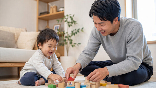 リビングで息子と積み木遊びをする日本人の父親