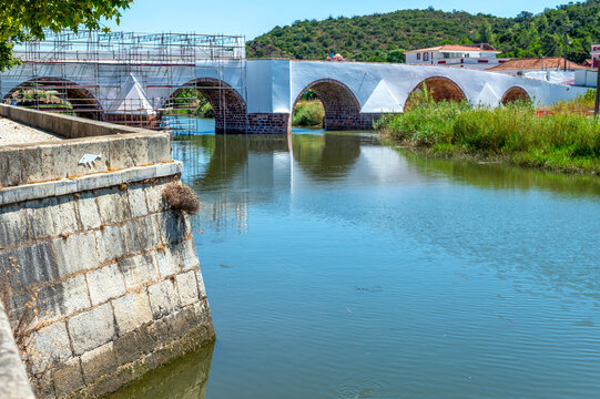 Magnificent ancient Roman bridge over Arade River in final stages of restoration in idyllic Algarve town Silves Portugal