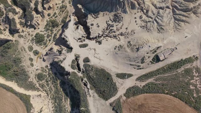 Aerial top view of eroded desert gullies and farmland edge