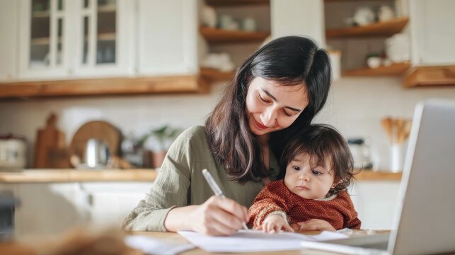 Mother balancing work and parenting at home with baby in cozy kitchen setting