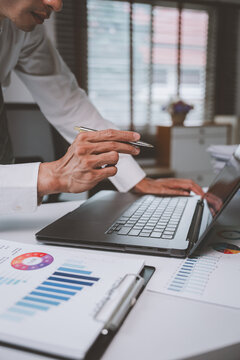 Business professional analyzing data on laptop in office
