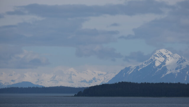 Breathtaking Alaska mountain glacier range view seen from outdoor deck of cruise ship liner sailing the Inside Passage transit with spectacular landscape wilderness scenery