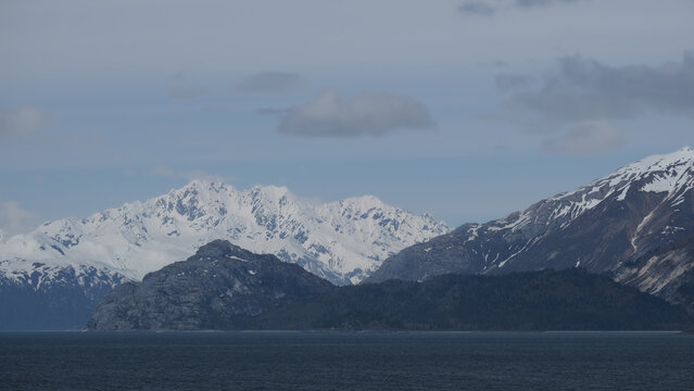 Breathtaking Alaska mountain glacier range view seen from outdoor deck of cruise ship liner sailing the Inside Passage transit with spectacular landscape wilderness scenery