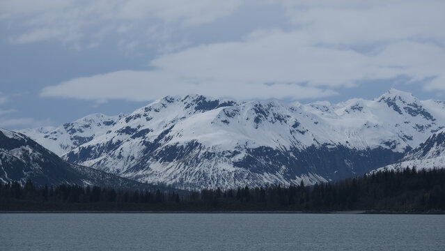 Breathtaking Alaska mountain glacier range view seen from outdoor deck of cruise ship liner sailing the Inside Passage transit with spectacular landscape wilderness scenery