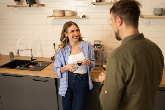 Happy couple drinks coffee and talks in the kitchen