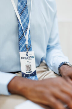 A businessman wears an accreditation badge at the workplace