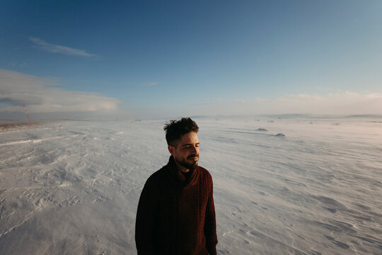 A bearded man experiences solitude in the snowy wilderness of Lapland