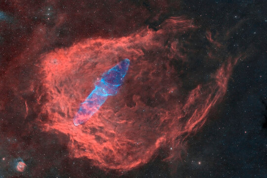 The red and blue Flying Bat Nebula glows in deep space