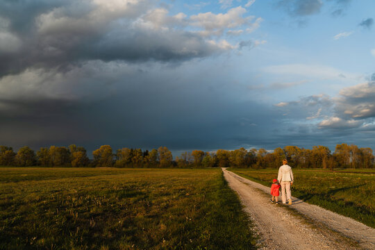 Mother and son walk on rural path in nature