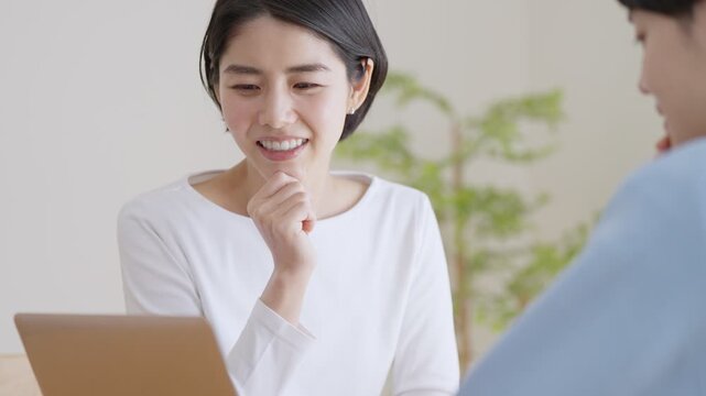 パソコンを見て会話する夫婦・カップル