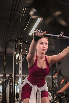 Woman does upper body workout on a cable machine at the gym