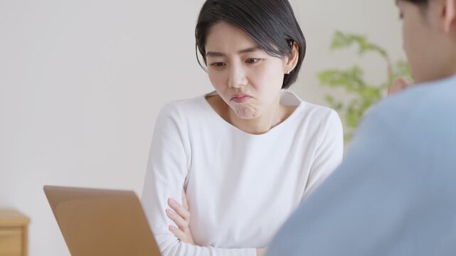 パソコンを見て会話する夫婦・カップル