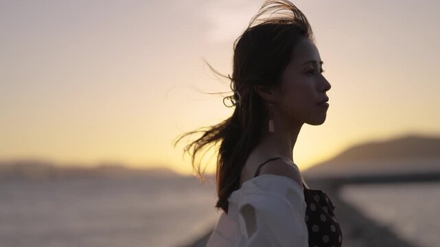 夕暮れの海にいる女性
