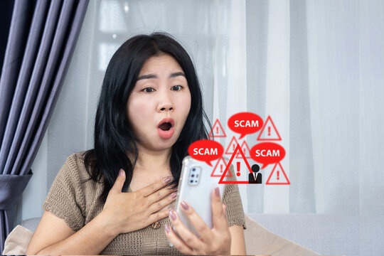 Shocked Asian woman looking at smartphone with red scam call and warning icons. Perfect for cyber crime, mobile fraud, phishing alert, data security, and technology concept