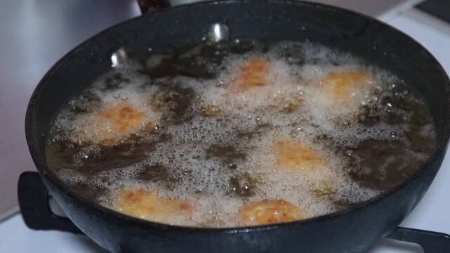 チキンカツを揚げる女性