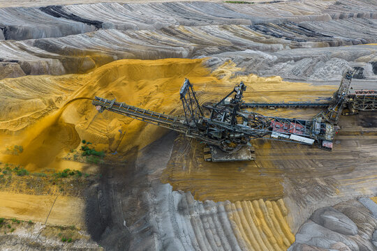 Aerial view of the Tagebau Hambach open-pit mine featuring a massive bucket-wheel excavator extracting material from deep sandy layers in Elsdorf, Nordrhein-Westfalen, Germany.