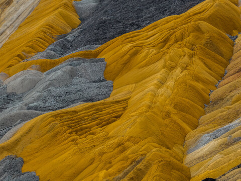 Aerial view of the colorful soil layers and sediment deposits at the Tagebau Hambach open-pit mine in Elsdorf, Nordrhein-Westfalen, Germany.