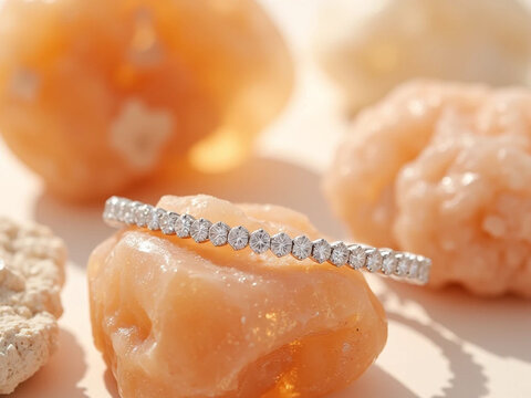 peach and white diamond-studded elongated ring on textured stone, soft diffused lighting, elegant minimalist jewelry close up