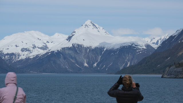 Breathtaking and impressive panoramic scenic view of Glacier Bay Fjord Inside Passage coast with lush mountain vegetation and trees during summer Last Frontier cruise with ice floating on water