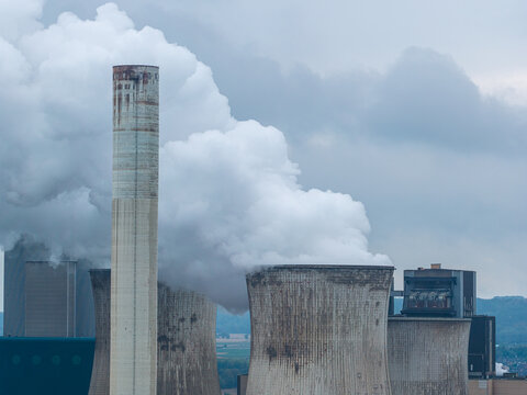 Aerial view of RWE Power AG Kraftwerk Neurath, BOA 23, featuring massive cooling towers emitting thick white steam against a cloudy sky in Grevenbroich, Nordrhein-Westfalen, Germany.
