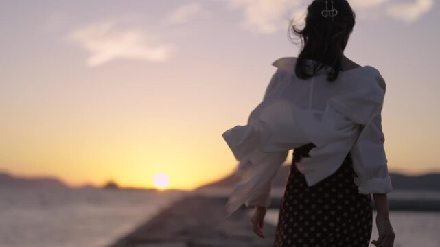 夕暮れの海にいる女性