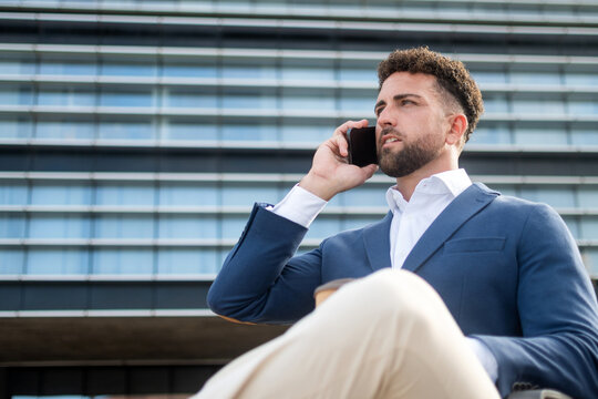 Businessman talking on smartphone during outdoor coffee break