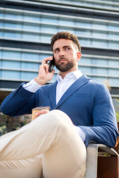 Businessman talking on smartphone during outdoor coffee break
