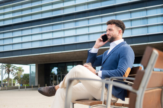 Businessman talking on smartphone during outdoor coffee break