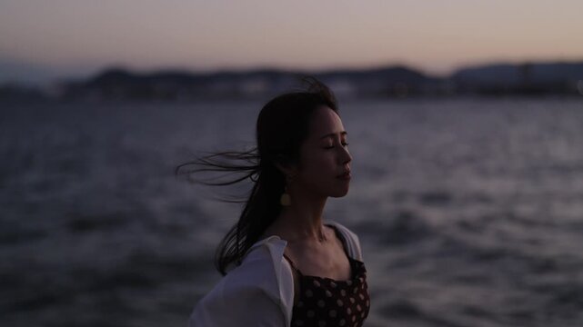 夕暮れの海にいる女性