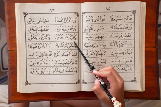 a child is reciting the Iqro. The Iqro book or iqra contains Arabic letters or Hijaiyah letters for learning to read the Quran, Al-Quran