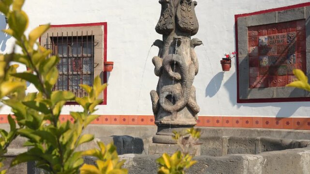Pila de las Culebras stone fountain with serpent sculptures and flowing water in Tapalpa Pueblo M&aacute;gico historic center, Jalisco, Mexico. Establishing shot.