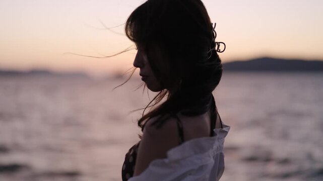夕暮れの海にいる女性