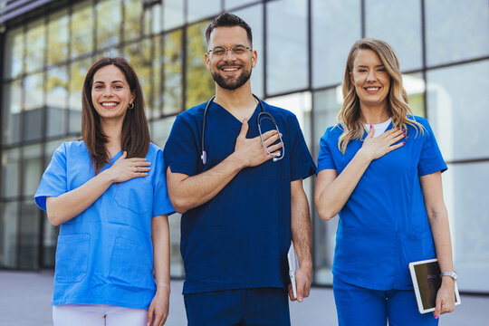 Smiling Healthcare Team of Nurses and Doctor in Scrubs Showing Unity and Compassion Outside Clinic
